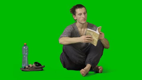 Barefooted male squats crosslegged and reads book. Footage with alpha channel. High quality keying without holes & chatter. File format - mov. Codeck - PNG+Alpha