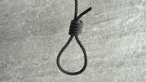 Noose hanging in front of stone wall film clip. Symbol of death, capital punishment and execution.