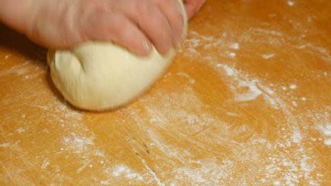 Baker kneading dough on table in flour. Closeup shot of domestic home made and handmade diy bakery. 4K UHD video footage.