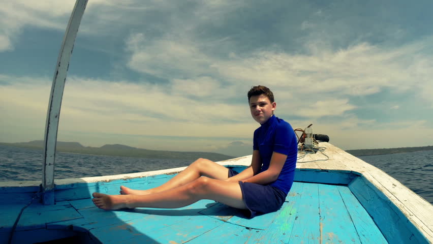 Young happy boy sitting on boat
