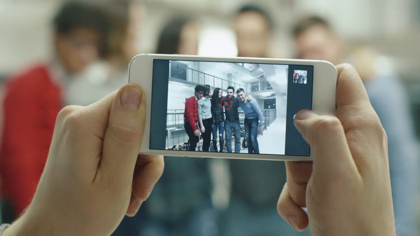 First view footage of a person taking a picture of students with a smartphone. Shot on RED Cinema Camera in 4K (UHD).