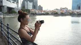 Outdoor summer smiling lifestyle portrait of pretty young woman having fun in the city in Singapore , take a photo around city so excited.