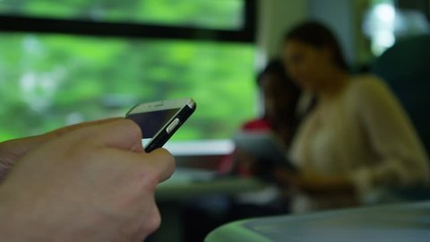 4k Close up on hands of young man using a smartphone on train journey