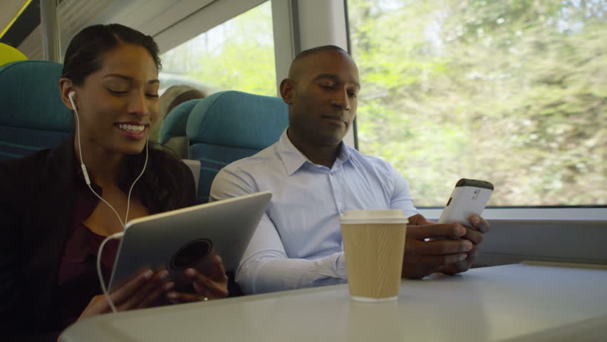 4K Attractive couple on train journey, using technology to pass the time.