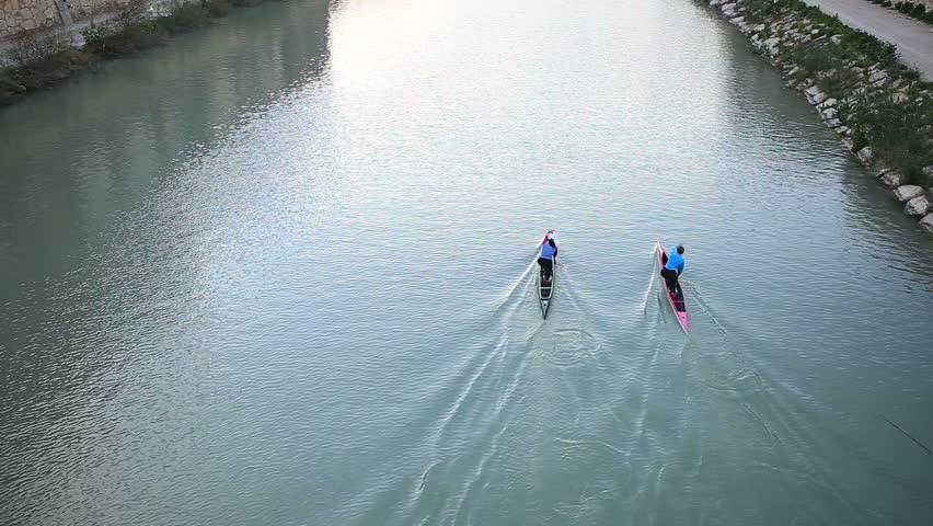 Paddling two boats in a river.