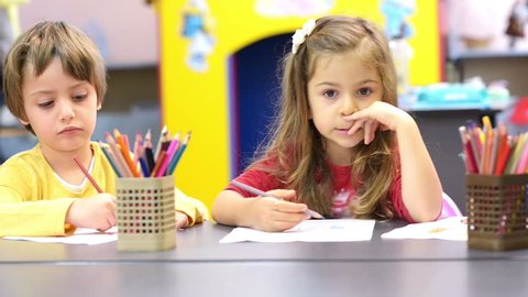 Three kids drawing at kindergarten