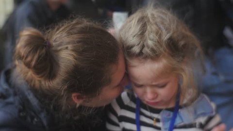 Woman Gives a Hug to Her Daughter and Smiling, Little Blonde Girl is Crying, Snuggling to Mom, Talking Something, Looking Somewhere, Tears Are Coming Down, Wet Face, Then Child Stops Crying 