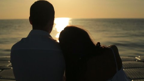 Silhouettes of romantic wedding couple on sunset in Egypt. Sea background
