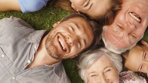 Overhead view of family lying in a garden with heads together
