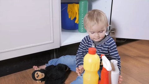 Small child playing with toxic household cleaners