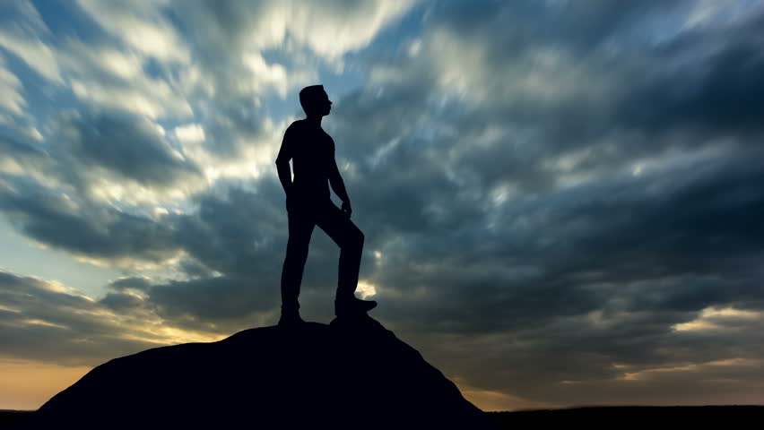 The man stand against the move clouds. Time lapse. Wide angle