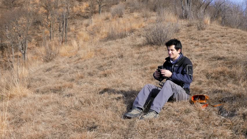 European guy looks at the landscape through the telescope