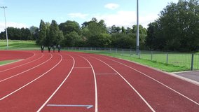 4K Drone footage of competitive businessmen racing each other at running track