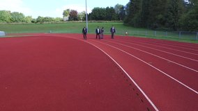 4K Drone footage of competitive businessmen racing each other at running track