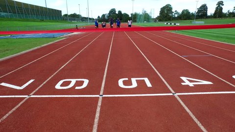 4K Drone footage of track athletes crossing finish line at running track