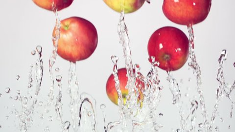red apple with splashes of water on a white background, slow motion