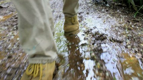 boots hiking down a muddy trail
