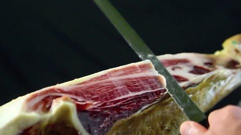 cutting iberian ham on traditional spanish style (handmade for tapas)