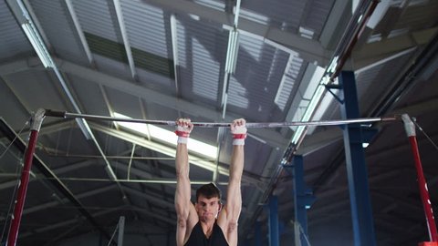 4K Professional male gymnast training on horizontal bar at the gymの動画素材