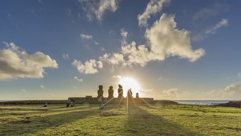 Inspiring daytime to sunset timelapse with Rapa Nui on the Isla de Pascua. Sun goes behind and clouds swirling above the famous MOAI statues - major landmark of Easter Island, Chile, Pacific ocean.