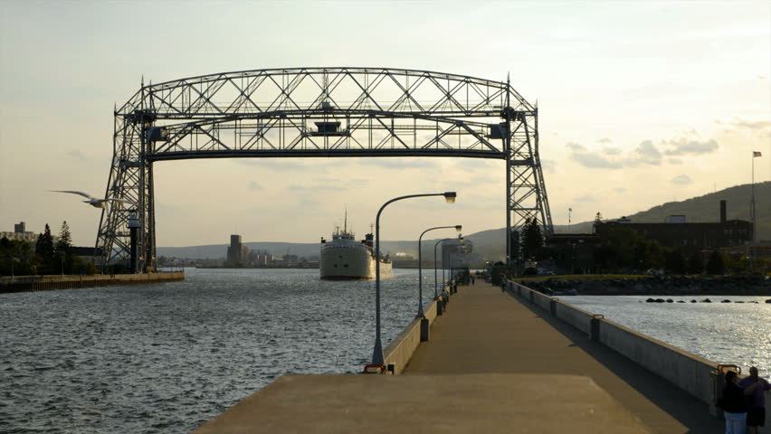 Time lapse of ship passing under lift bridge and bridge going back down.