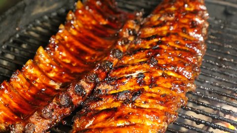 BBQ spicy marinated and smoked pork spareribs on the hot charcoal gril with bright flames