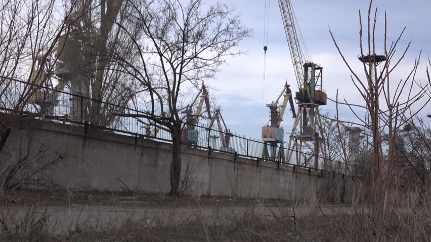 Behind the fence shipbuilding cranes in port, Central Europe