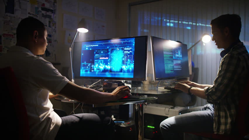 4K Young creative computer design team working together in dark office.