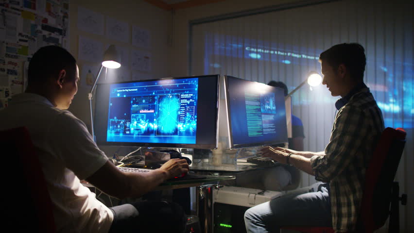 4K Young creative computer design team working together in dark office.