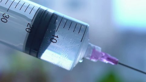 Close-up shot of syringe during injection, drug addiction problem, aids epidemic, vaccination. Medicine liquid delivering to patient body, hospital treatment, health care system, clinic therapy
