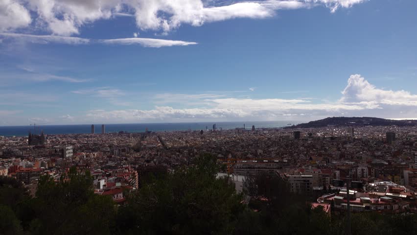 BARCELONA, SPAIN - FEBRUARY 28, 2016: Aerial Barcelona cityscape from three cross hill. pan shot at sunny daytime. Wide angle perspective, from Balearic Sea and Montjuic hill, to Tibidabo mountains