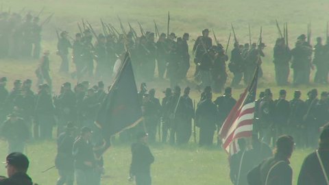 GETTYSBURG, PENNSYLVANIA - JULY 2008 - large-scale, epic Civil War anniversary reenactment -- in the middle of battle.  Wide of Union and Confederate soldiers firing and fighting, cannons and smoke.