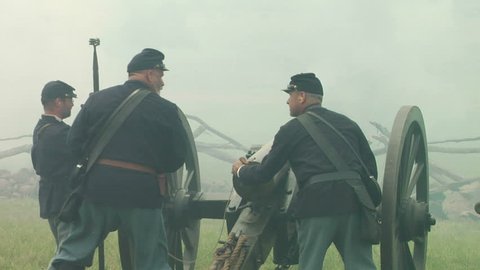 GETTYSBURG, PENNSYLVANIA - JULY 2008 - large-scale, epic Civil War anniversary reenactment -- in the middle of battle.  Re-enactor Union Cannon artillery soldiers firing and fighting cannons and smoke