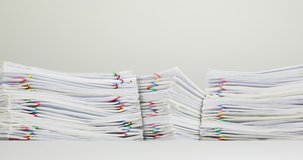 Stack overload paperwork of report and receipt with colorful paperclip place on white table time lapse. Pile of document is decreasing as work is going to be successful. Business concept footage.