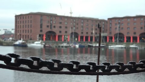 Albert docks in Liverpool, focus pull on chain in foreground The Albert Dock is a complex of Victorian dock buildings and warehouses in Liverpool, England. march 18th 2016