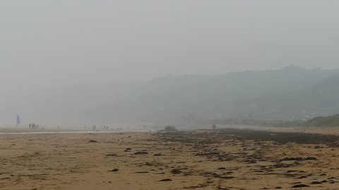 Foggy view of the sea shore in Omaha Beach where the white sand is found and the small waves on the sea