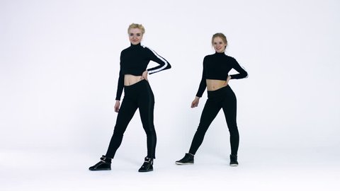 Dancing two girls on a white background in studio. 4K 30fps ProRes (HQ)