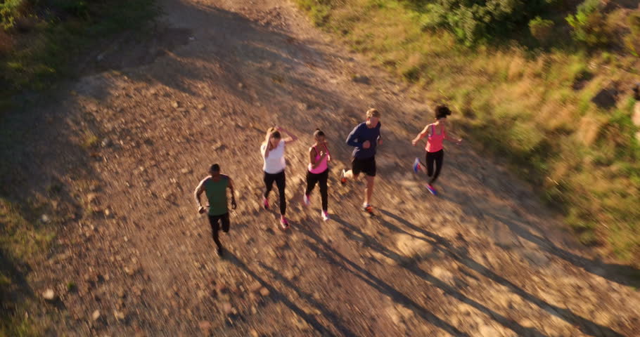 Back view of four athletic friends engaged in a outdoors running training in a road surrounded by nature. Aerial drone view. | Shutterstock HD Video #15332302