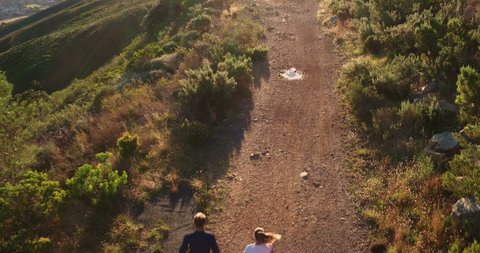 Multi-ethnic group of athletes running together on a panoramic nature trail. Aerial drone view. Stockvideó