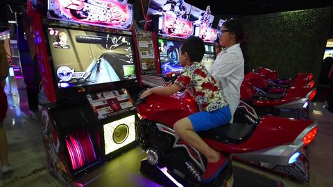BANGKOK, THAILAND - MARCH 17, 2016: Kid playing arcade video game at an amusement park in MBK mall 