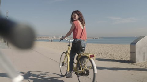 Young Adult Tourists cycling on beach in summer Stock Video