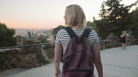 Young adult woman admiring view backpack in park Barcelona