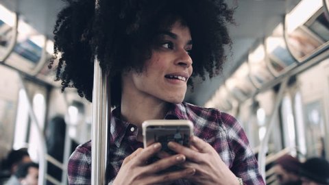 Afro American Female on subway with smart phone