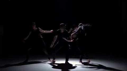 Contemporary dance of four talanted dancers on black, shadow, slow motion