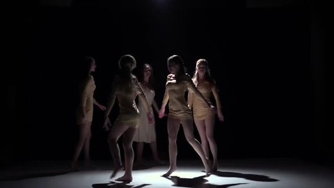 Contemporary dance of five talanted girls in white dresses, on black, shadow, slow motion