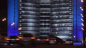 Modern skyscraper building in Moscow illuminated at night with cars passing by. Time lapse video
