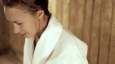 Relaxed woman relaxing in a wooden sauna