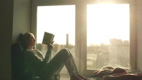 beautiful young woman sitting on window sill with coffee end reading book on background of sunset - Powered by Shutterstock - Get 15% off with code: PIKWIZARD15