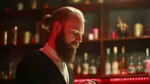Handsome barman professional at posh bar making cocktail drinks