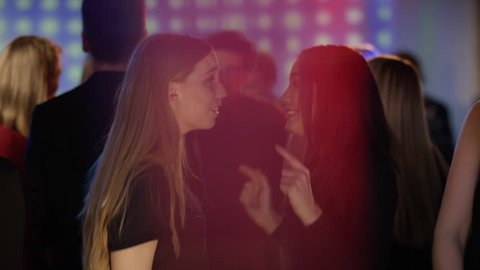 two girls at club dancing close and singing